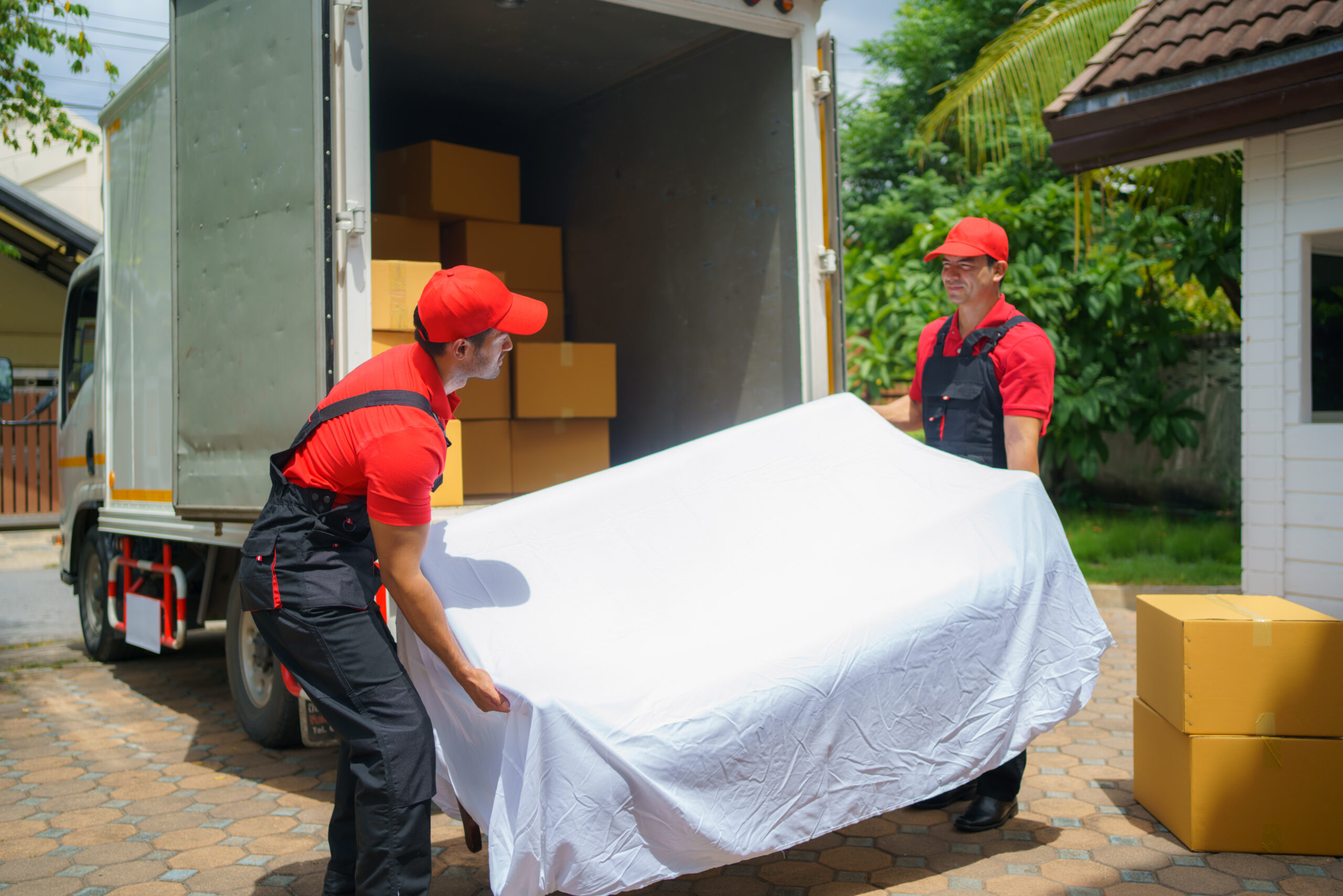 two male company movers assisting in sofa unloading